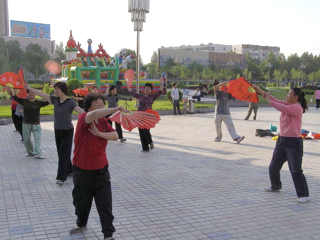 Frühmorgens auf einem Platz im Zentrum von Yili, Provinz Xinjiang, Fächer Qigong